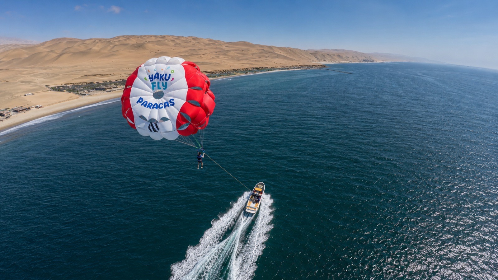 Vista aérea de un parapente sobre el azul profundo del mar de Paracas