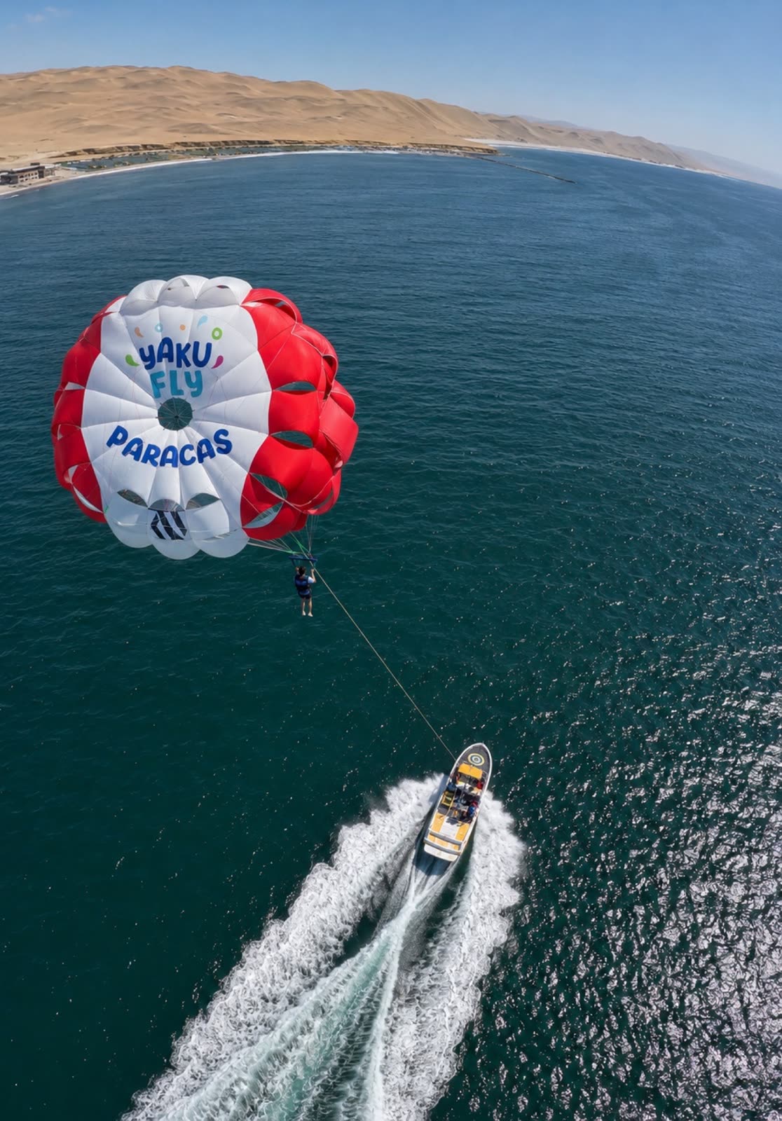 Parapente sobre el mar turquesa de Paracas visto desde arriba