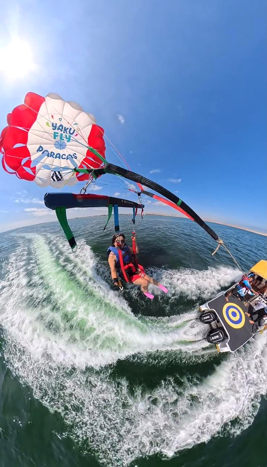 Vista aérea con GoPro de la lancha y la estela durante un vuelo de parasailing en Paracas
